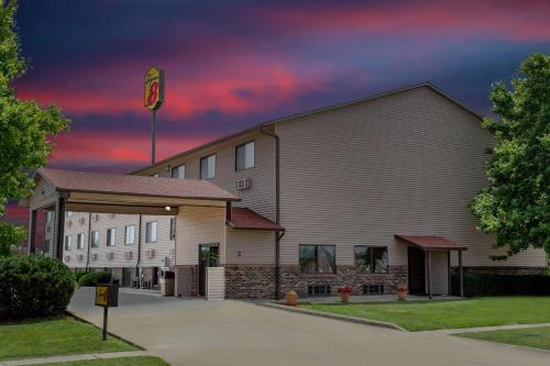 a building with a flag on top of it at Super 8 by Wyndham Normal Bloomington in Bloomington