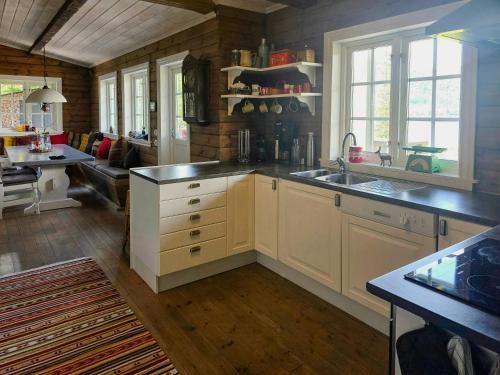 a kitchen with a sink and a living room at Mountain Cabin With Views Of Bonsenås in Tuddal