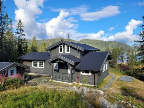 a gray house with a black roof at Mountain Cabin With Views Of Bonsenås in Tuddal
