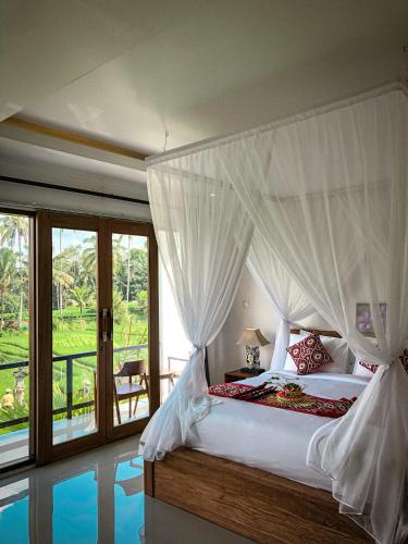 een slaapkamer met een hemelbed en een zwembad bij Kemala Hospitality in Tegalalang