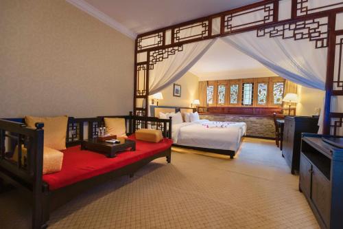 Un dormitorio con una cama y un sofá en una habitación. en Lijiang Wangfu Hotel, en Lijiang