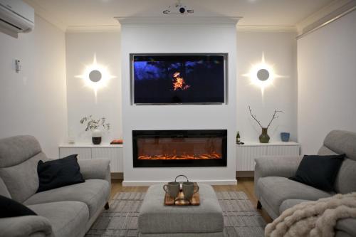 a living room with two couches and a fireplace at Entire home in Cranbourne West in Cranbourne West