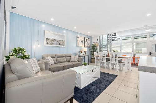 a living room with a couch and a dining room at Paradiso Resort by Kingscliff Accommodation in Kingscliff