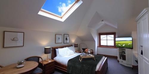 a bedroom with a bed and a tv and a table at Sandstone Suites - In the heart of Port Fairy in Port Fairy