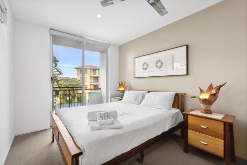 Paradiso Resort by Kingscliff Accommodation في كينغسكليف: غرفة نوم بها سرير ونافذة كبيرة