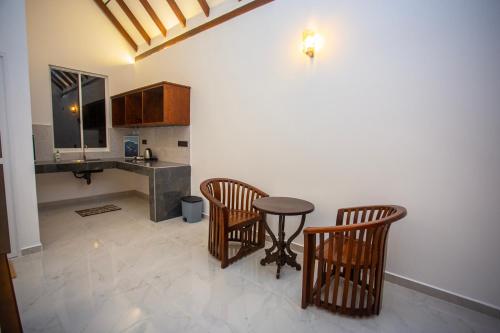 a kitchen with two chairs and a table and a counter at Ceylon Princes Villa in Ahangama