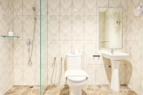 a bathroom with a toilet and a sink and a shower at Q Collection Macalister formerly known as Apple Hotel Penang in George Town