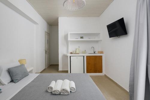 een witte kamer met drie paar schoenen op de vloer bij Vavoulas Village in Mikri Vigla