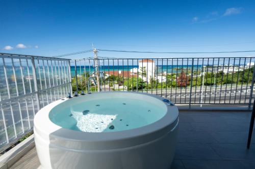 a bath tub on a balcony with a view of the ocean at Emerald Ocean Villa in Onna