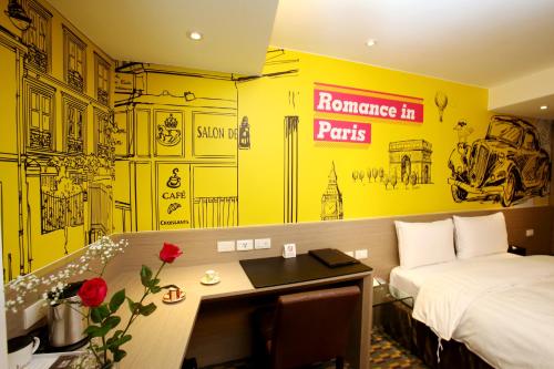 a hotel room with a bed and a desk and a bed and a room at Chiayi Look Hotel in Chiayi City
