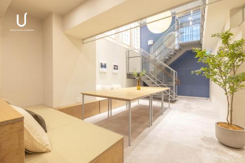 a room with a table and a staircase at unito hotel residence Kyoto Station North in Kyoto