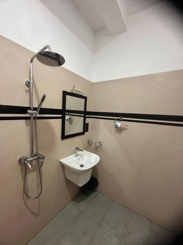 un baño con lavabo y ducha en Lyra Mirissa, en Mirissa