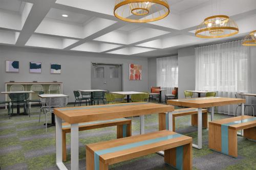 a waiting room with tables and chairs and tablesktop at Spark by Hilton Washington Meadowlands Blvd in Washington
