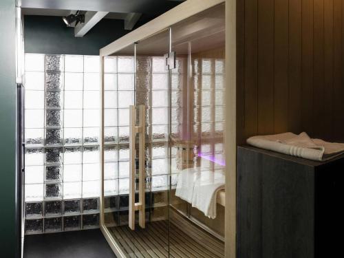 a room with a large window with a bed in it at Ibis Pontarlier in Pontarlier