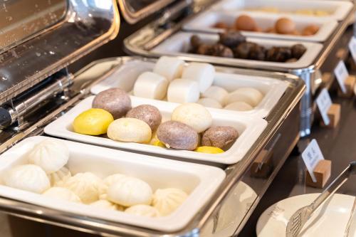 une rangée de plateaux remplis de différents types de nourriture dans l'établissement Hanting Hotel Shanghai Jiaotong University Jiangchuan Road Subway Station 2, à Shanghai