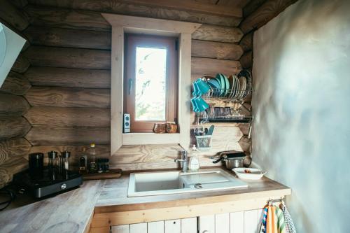 a kitchen with a sink and a window at Romantic stay at loghouse VäikeTeeMaja in Üksnurme