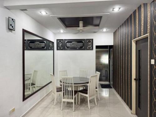 a dining room with a table and chairs at D' Mutiara Homestay in Simpang Ampat