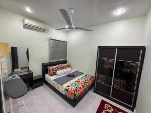 a bedroom with a bed and a ceiling fan at D' Mutiara Homestay in Simpang Ampat