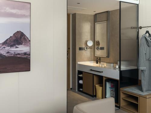 ein Badezimmer mit Waschbecken und Spiegel in der Unterkunft 上海静安寺西康路亚朵酒店 in Shanghai