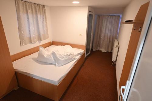 a small room with a white bed in it at Sportul Alpin in Lupeni