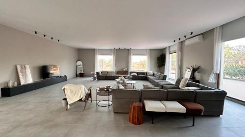 a large living room with a couch and a table at Al Ain Farm Escape with Private Pool , Mini Golf , and Firepit in Bin Aḩmad