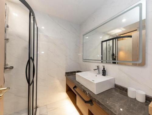 een witte badkamer met een wastafel en een spiegel bij Starway Hotel Shanghai Hongqiao National Exhibition and Convention Center Beiqing Road in Shanghai