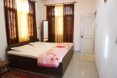 a bedroom with a bed with a pink blanket on it at Guler House in Jāmb