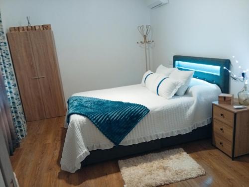 a bedroom with a bed with a blue headboard at O Caminho Azul in Olivenza