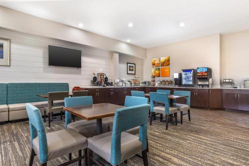 a waiting room with tables and chairs and a tv at Comfort Suites Chincoteague Island Bayfront Resort in Chincoteague