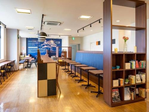 a waiting room with a row of tables and chairs at Comfort Hotel Hikone in Hikone