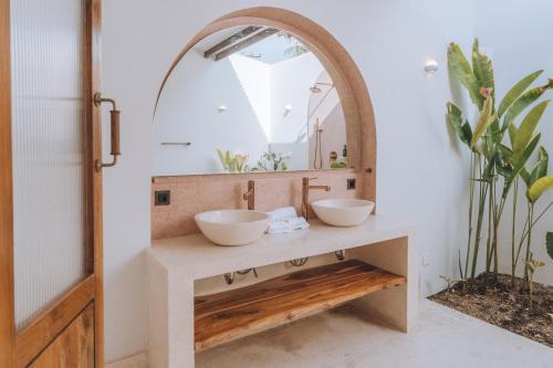 a bathroom with two sinks and a mirror at Lumora Boutique Villas in Gili Trawangan