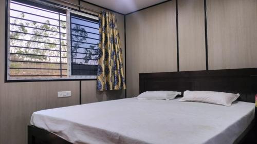 une chambre avec un grand lit et une fenêtre dans l'établissement Rr resort, à Araku