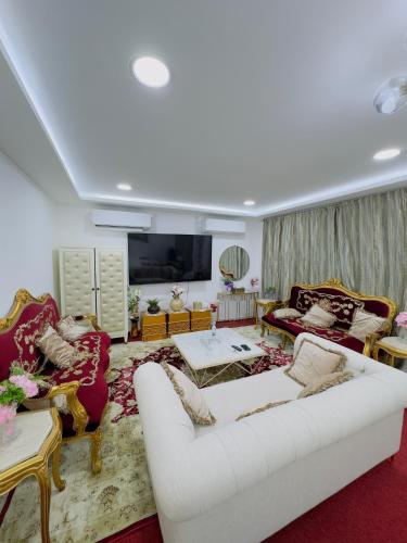 ein Wohnzimmer mit 2 weißen Sofas und einem TV in der Unterkunft modern private studio reteat , al manhal-7 in Abu Dhabi
