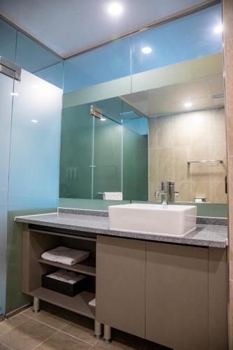 ein Badezimmer mit Waschbecken und Spiegel in der Unterkunft Hotel Fox Arthall in Daegu