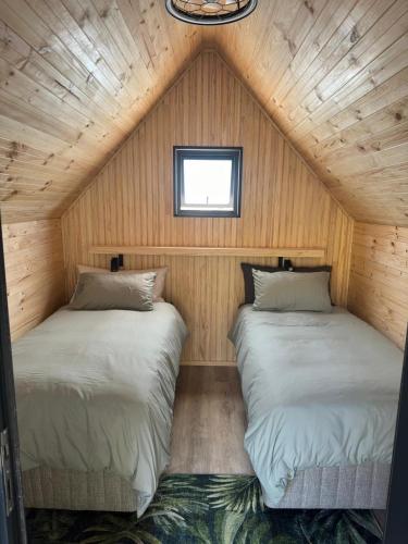 two beds in a small room with wooden walls at Baviaanskloof Laaste Kamp - Wild Bush Camping in Sandvlakte