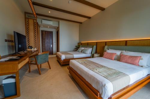 a bedroom with a large bed and a desk and a desk at Cebu Beach Club in Argao