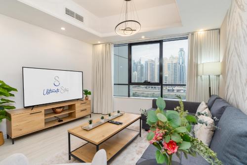 a living room with a couch and a tv at Ultimate Stay - Modern 1BR with City View Rooftop Pool Access in Dubai