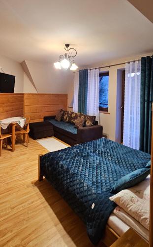 a bedroom with a large bed and a couch at Maria Chyc wynajem pokoi gościnnych in Zakopane
