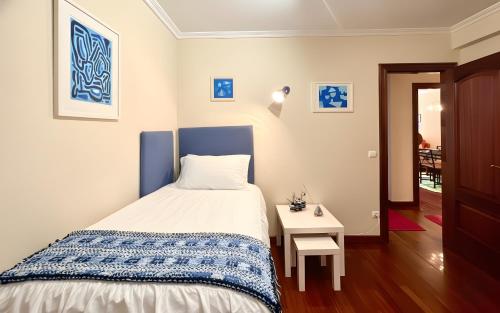 een kleine slaapkamer met een bed en een tafel bij Holibai, Chuliña, Vacaciones Familiares en Baiona, Espacio, Piscina y Playa a un Paseo in Baiona