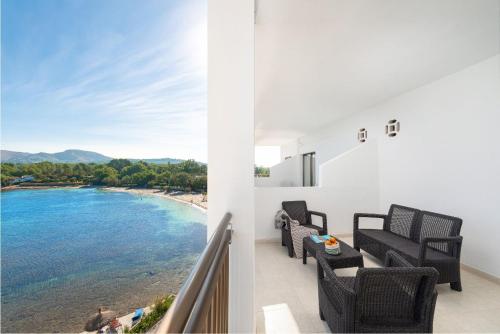 a balcony with chairs and a view of the ocean at Hotel Moré in Alcudia