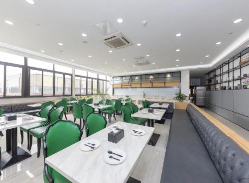 een eetkamer met tafels en groene stoelen bij Starway Hotel Shanghai Hongqiao National Exhibition and Convention Center Beiqing Road in Shanghai