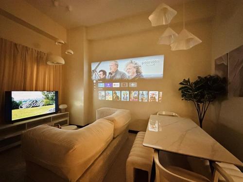 a living room with a couch and a flat screen tv at Cloud Cinema by Kozy Mood near BGC in Manila