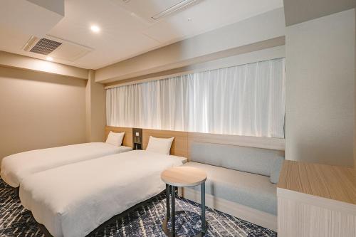 a hotel room with two beds and a window at Washington R&B Hotel Shin Yokohama Ekimae in Yokohama