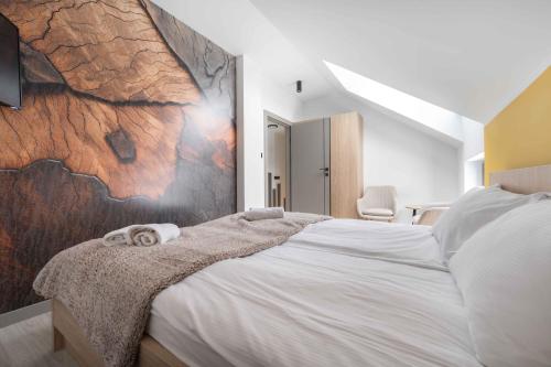 ヴィスワにあるApartament na Krętej z sauną i kominkiem - Dream Apartのタオルが敷かれた大きなベッドのある寝室