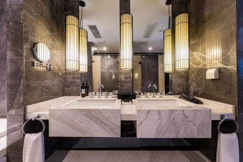 Un baño con dos lavabos y una bañera grande. en Guangzhou Baiyun Airport Orange Crystal Hotel, en Huadu