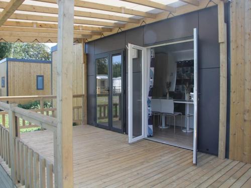 a house with a deck with a sliding glass door at Modern 6-person chalet in the Frisian countryside, 3 bedrooms and WiFi in De Veenhoop