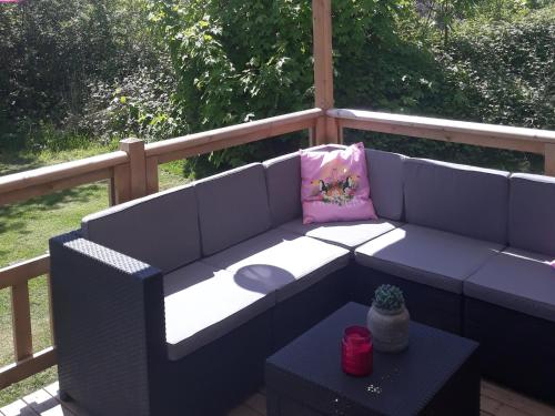 a blue couch with a pink pillow and a table at Modern 6-person chalet in the Frisian countryside, 3 bedrooms and WiFi in De Veenhoop