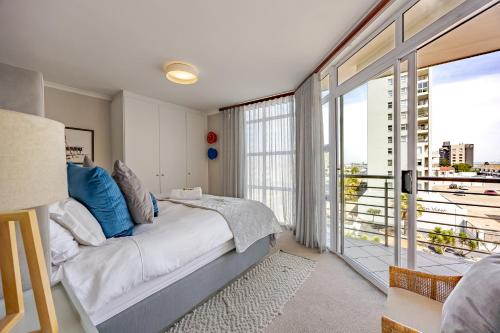 a bedroom with a bed and a large window at Luxury Ocean View Beachfront 2 bed apartment -206 The Waves, Blouberg, Cape Town in Bloubergstrand