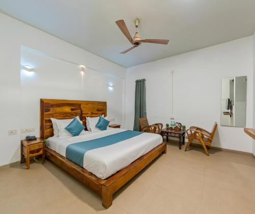 a bedroom with a large bed and a ceiling fan at Hotel Zorba Inn in Kolhapur