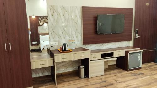 een hotelkamer met een bureau en een televisie aan de muur bij Pink Mahal Hotel & Resort in Jaipur